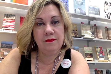 Selfie of Clare Hitchens in front of WLUPress bookshelves