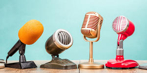Bright retro microphones stand against a blue tone background